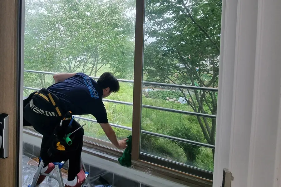 기술자가 진료실 창에 필름을 부착하고 정리하는 모습